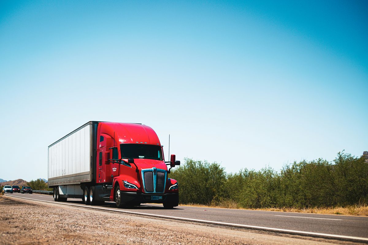 Red semi truck hauling on the highway